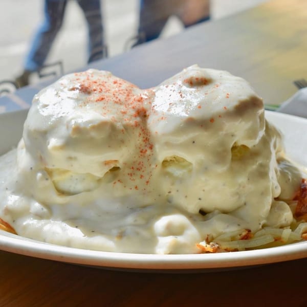 Biscuits and gravy with hash browns, topped with paprika, from Breakfast Club.